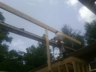 Carpenter setting a ridge beam over a new addition frame — Ice Dam Removal by Roofing Brothers in Lansdowne