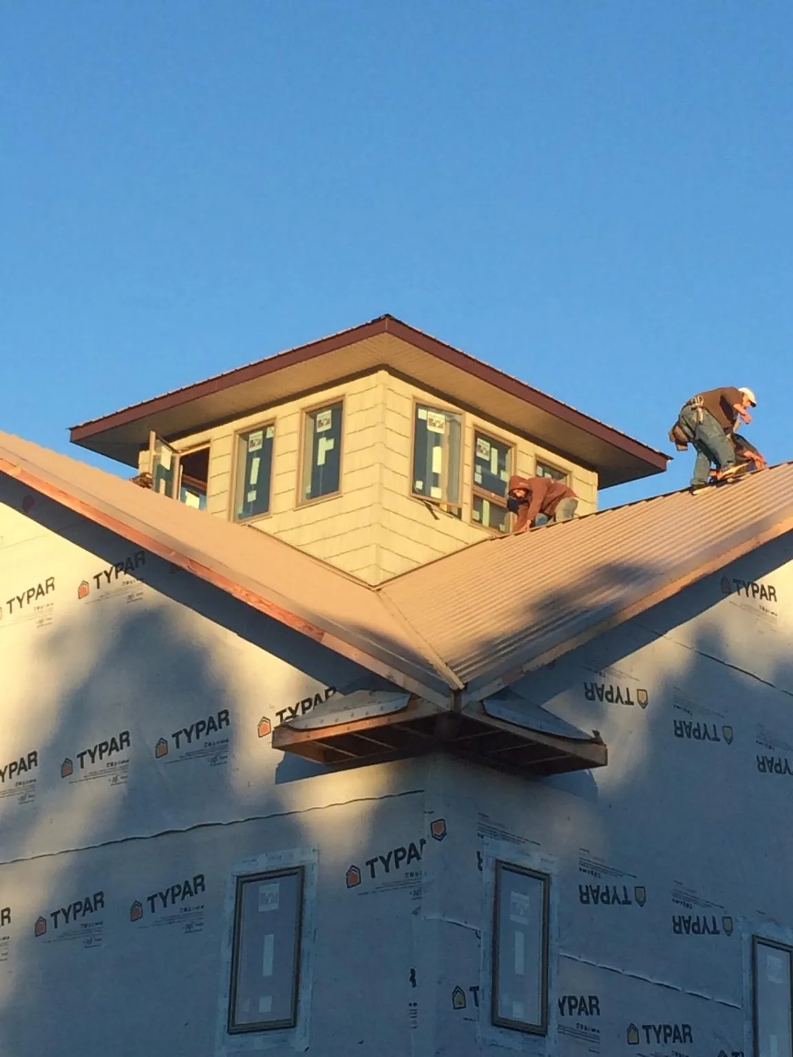Roofers working around a rooftop cupola on a new metal roof at sunset — Roof Waterproofing in Lansdowne by Roofing Brothers